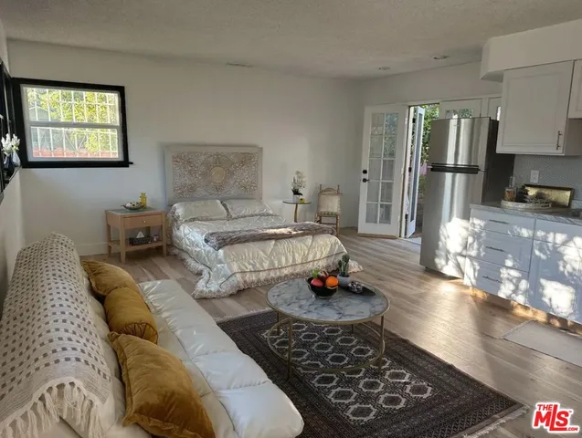 a spacious bedroom with a bed a couch and dresser