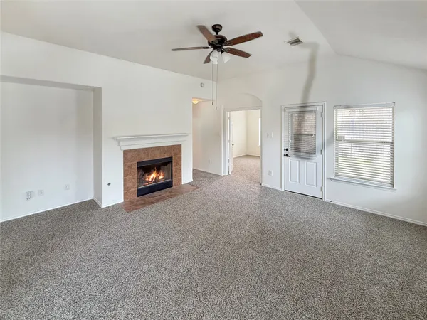 a big room with chandelier fan and fireplace