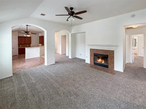 a view of a livingroom with a fireplace a chandelier fan and a fireplace