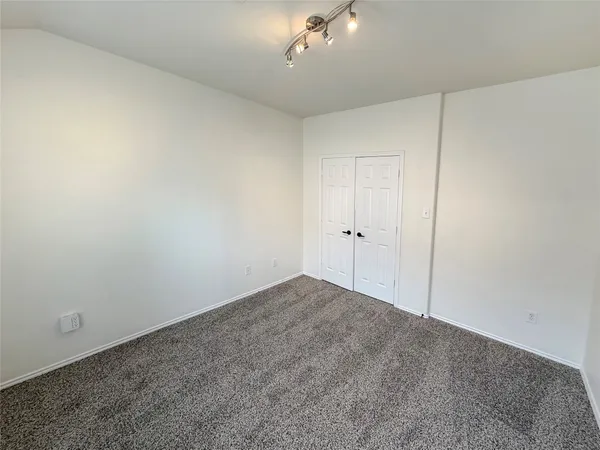 a view of an empty room and a chandelier fan