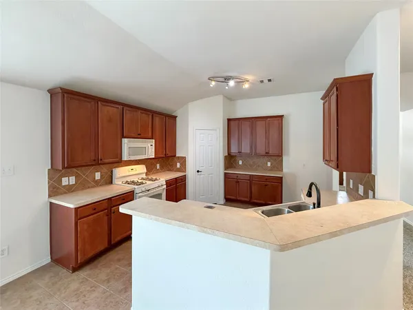 a kitchen with stainless steel appliances a sink stove and cabinets