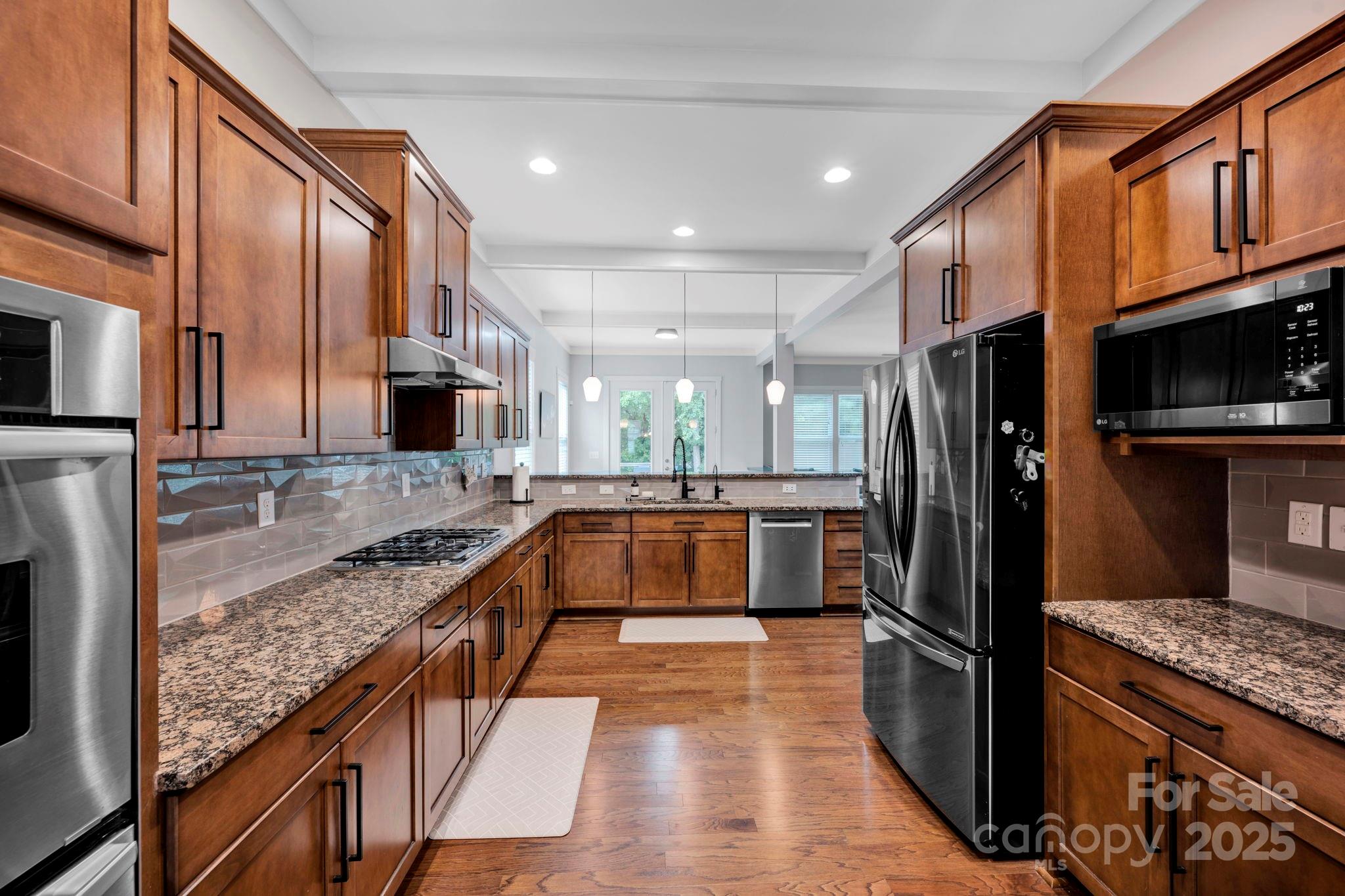 3076 Amaranth Drive Tega Cay, SC 29708 - Photo 11 of 39 a large kitchen with stainless steel appliances granite countertop a refrigerator a stove and a sink