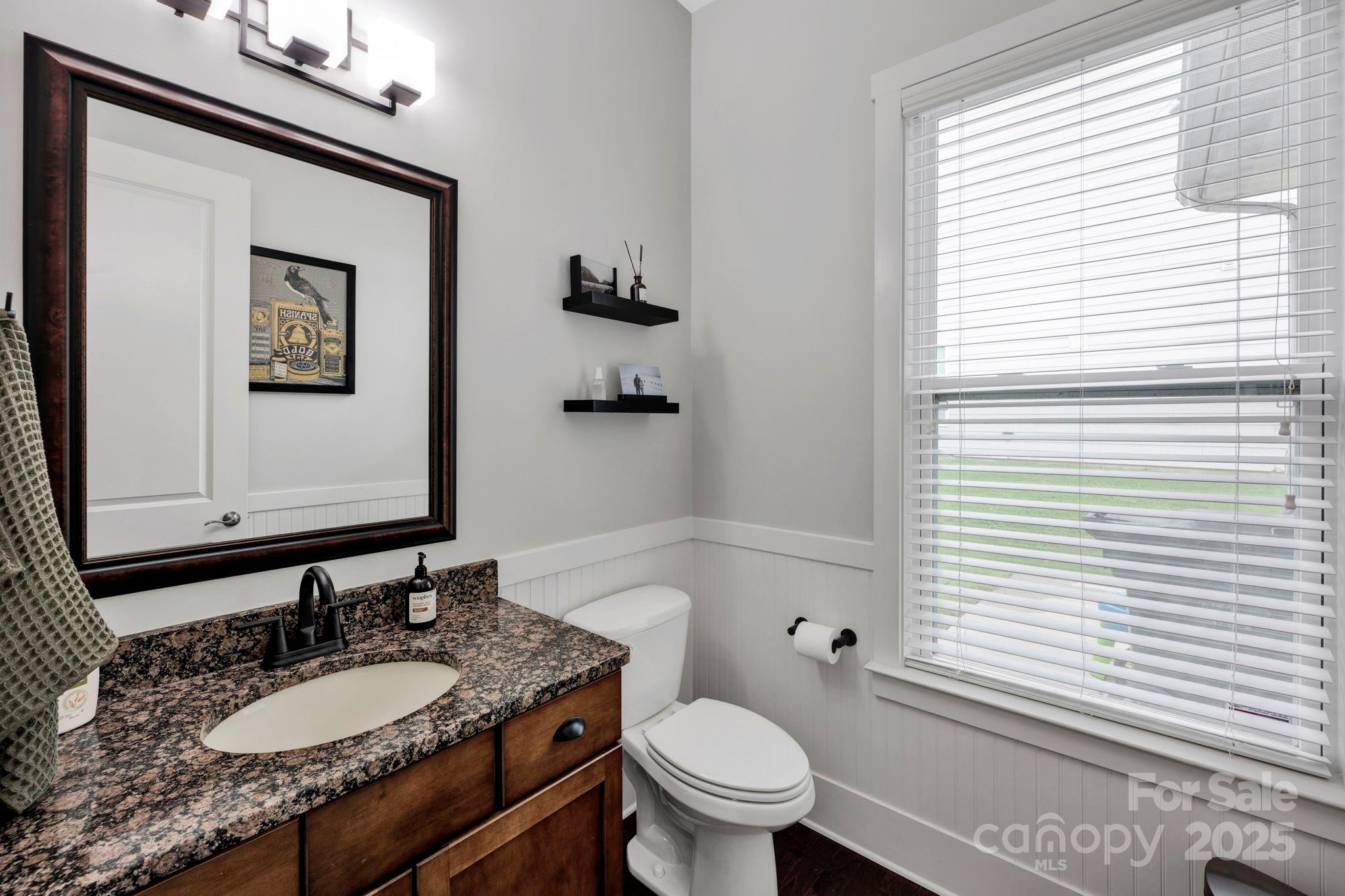 3076 Amaranth Drive Tega Cay, SC 29708 - Photo 16 of 39 a bathroom with a granite countertop toilet a sink a mirror and a window