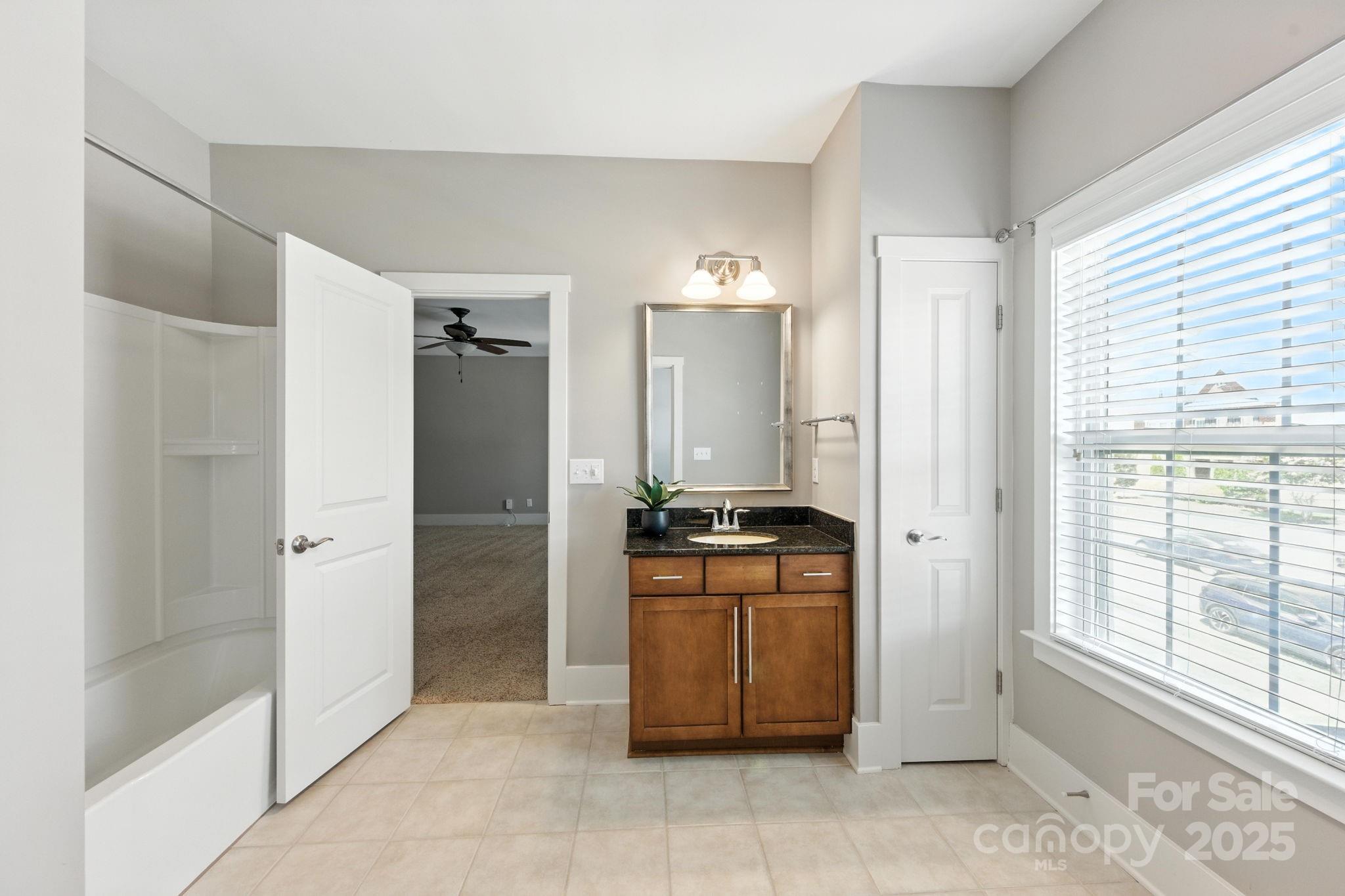 3076 Amaranth Drive Tega Cay, SC 29708 - Photo 27 of 39 a bathroom with a tub shower and sink