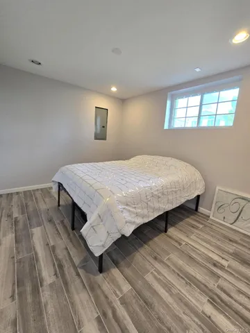 a bedroom with a bed and wooden floor