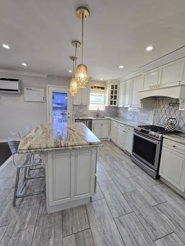 a kitchen with stainless steel appliances granite countertop a sink a stove and a wooden floors