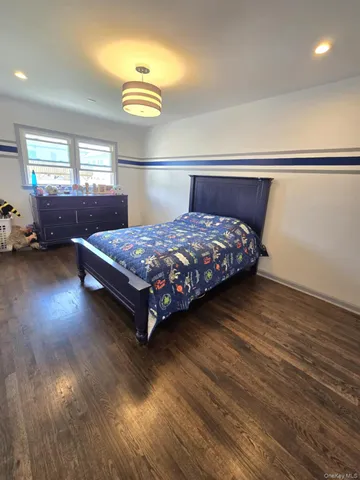 a bedroom with a bed window and dresser