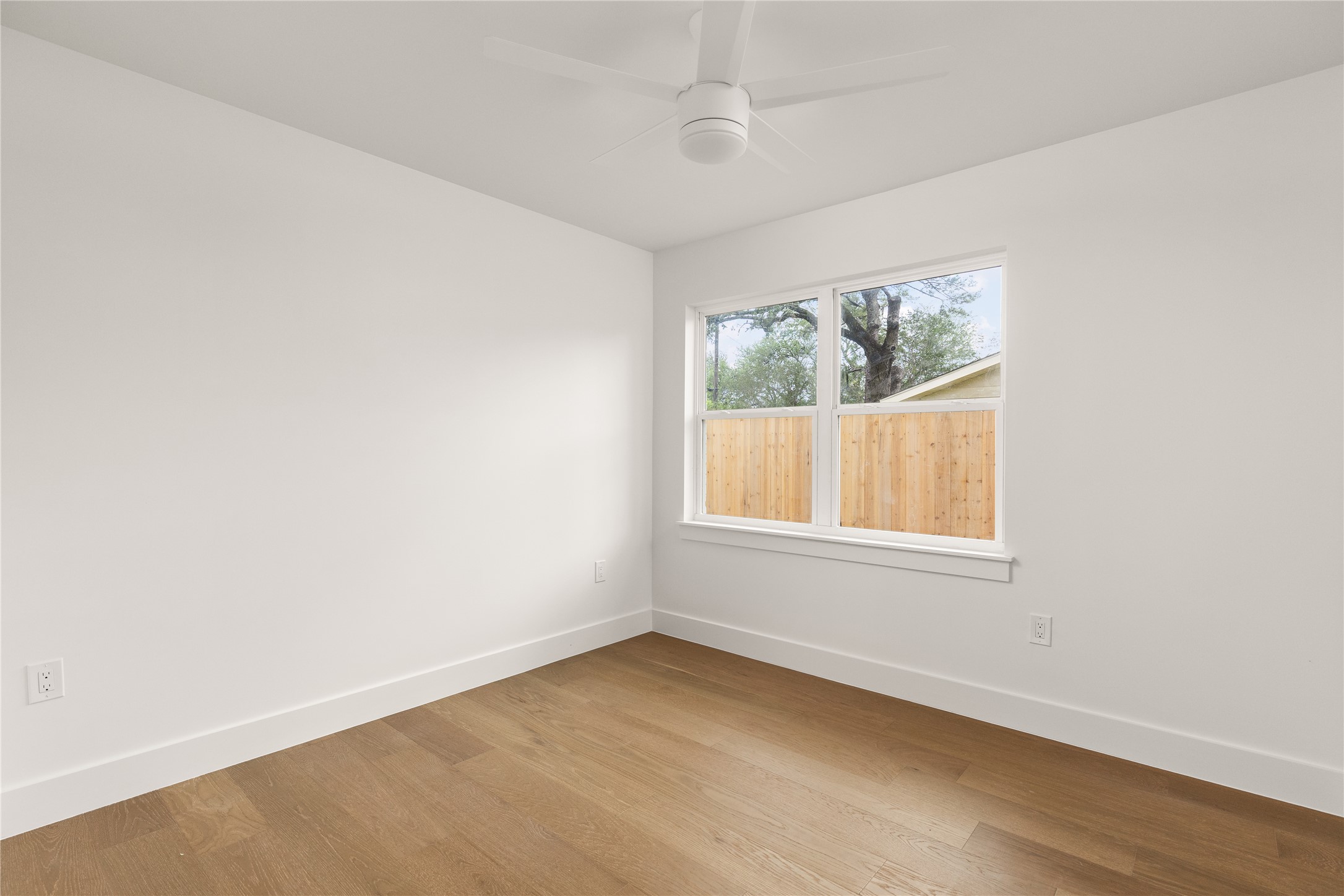 4501 Pack Saddle Pass Austin, TX 78745 - Photo 30 of 37 Room featuring wood-finish flooring, white baseboards, and a modern ceiling fan