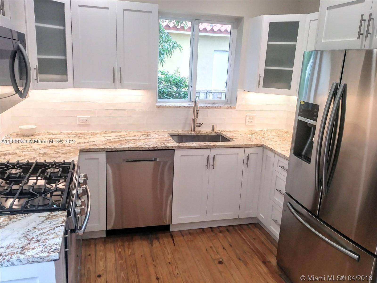 610 Southwest 25th Road Miami, FL 33129 - Photo 13 of 30 a kitchen with a sink a refrigerator a window and wooden floor