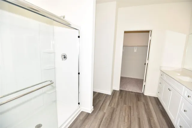 a view of bathroom with a hardwood floor and a hallway