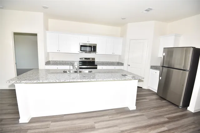 a kitchen with stainless steel appliances granite countertop a refrigerator a stove a sink and a granite counter tops