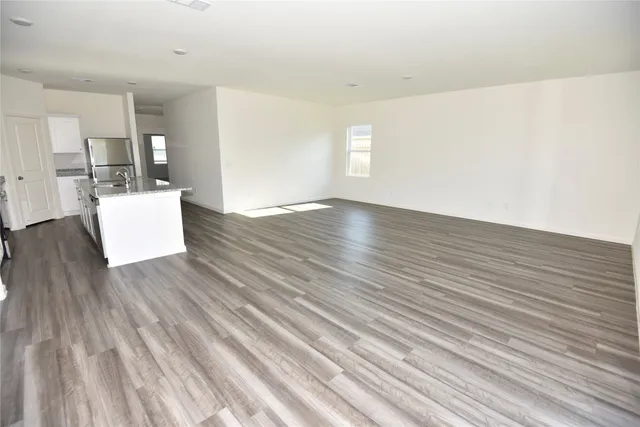a view of kitchen and hall with wooden floor