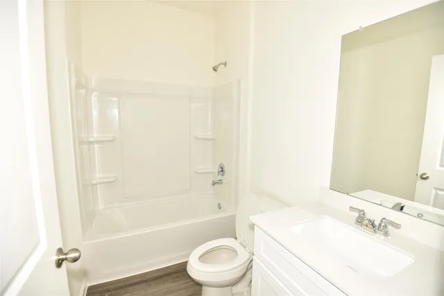 a bathroom with a bathtub shower sink vanity and a toilet