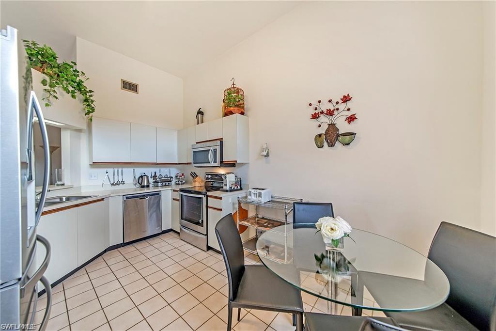 643 Beachwalk Circle, Unit D202 Naples, FL 34108 - Photo 2 of 22 a kitchen with a table and chairs in it