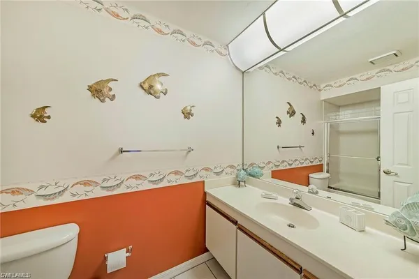 a bathroom with a sink mirror vanity and toilet