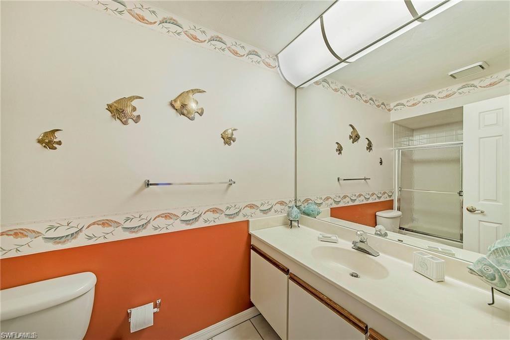 643 Beachwalk Circle, Unit D202 Naples, FL 34108 - Photo 6 of 22 a bathroom with a sink mirror vanity and toilet