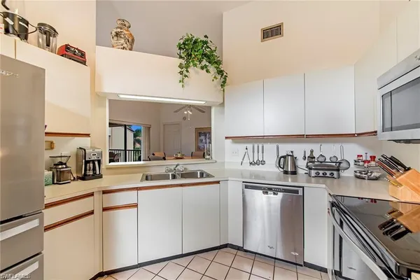 a kitchen with a sink dishwasher stove and white cabinets