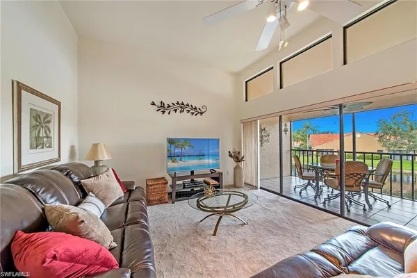 a living room with furniture a ceiling fan and a rug