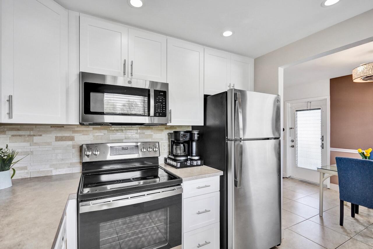 505 Monaco Way Delray Beach, FL 33446 - Photo 21 of 58 a kitchen with a refrigerator stove and microwave