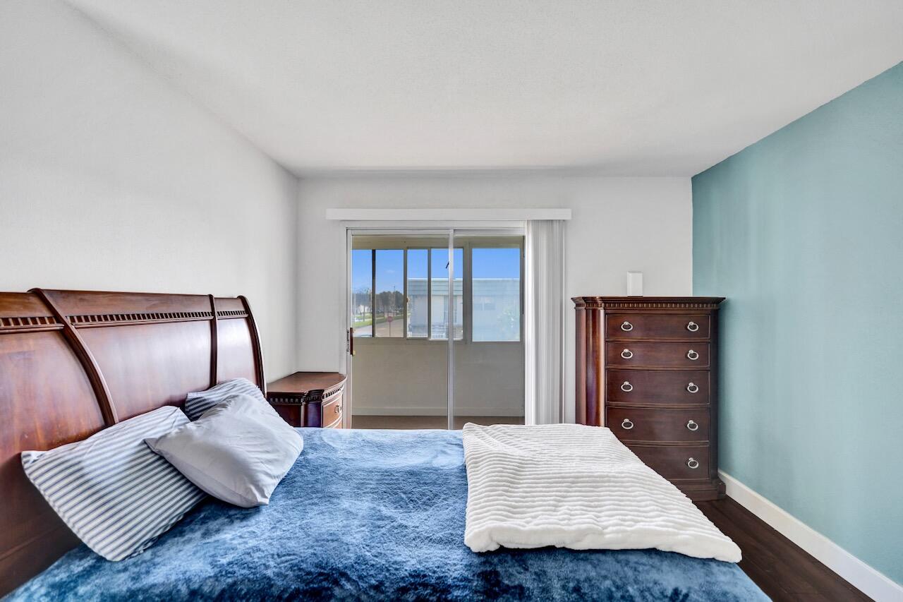 505 Monaco Way Delray Beach, FL 33446 - Photo 26 of 58 a bedroom with a bed and wooden floor