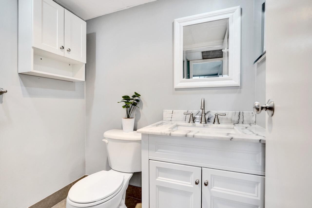 505 Monaco Way Delray Beach, FL 33446 - Photo 30 of 58 a bathroom with a sink vanity mirror and toilet