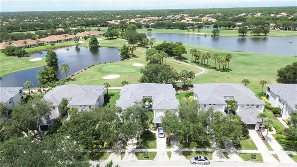 an aerial view of residential houses with outdoor space and lake view
