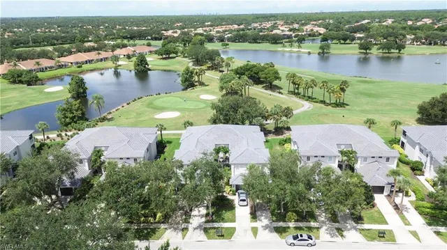 an aerial view of residential houses with outdoor space and lake view