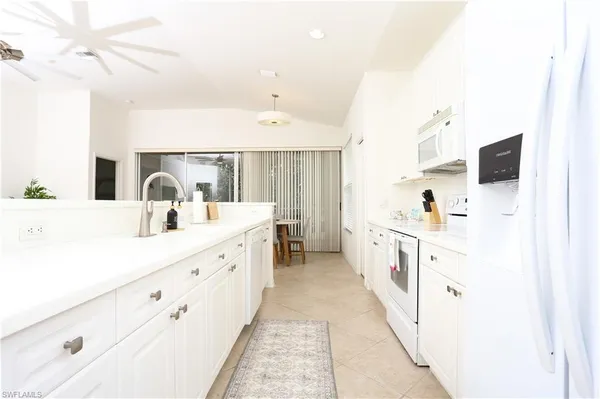 a large white kitchen with cabinets