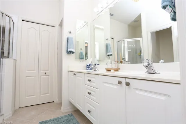 a bathroom with a double vanity sink a mirror and a shower