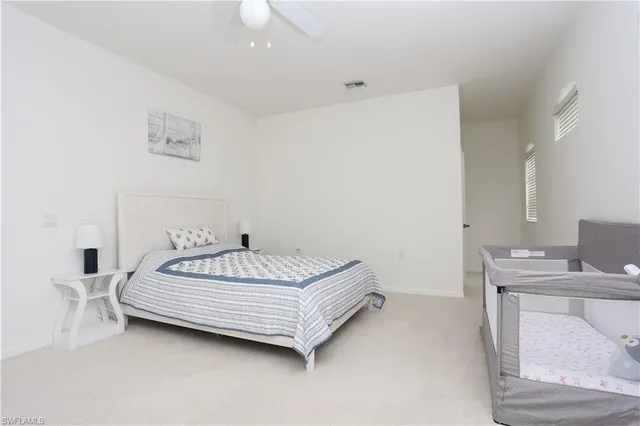 a bed sitting in a bedroom next to a window with a sink