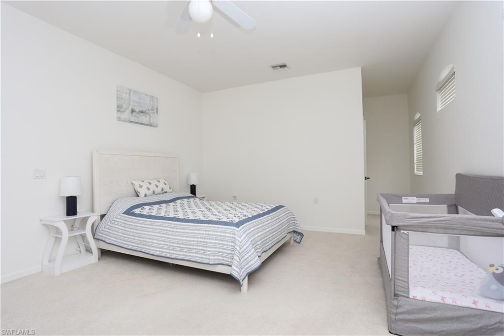 1937 Crestview Way, Unit 171 Naples, FL 34119 - Photo 22 of 39 a bed sitting in a bedroom next to a window with a sink