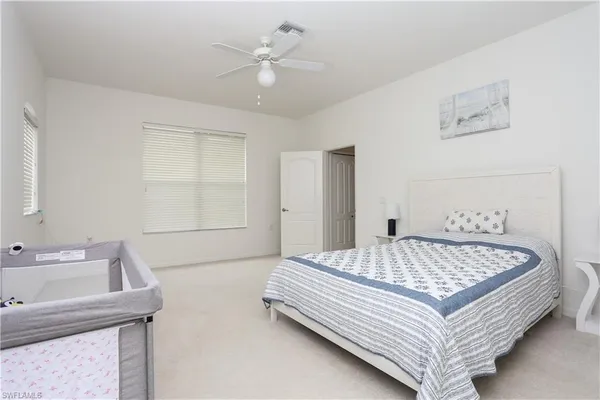a bed sitting in a spacious bedroom next to a window