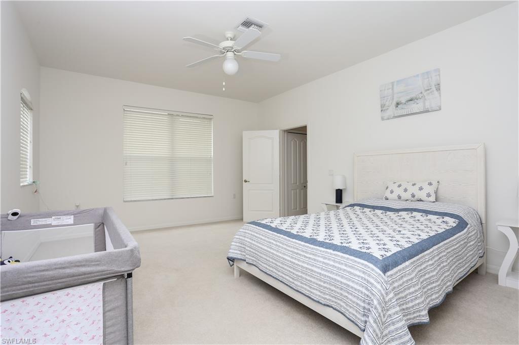 1937 Crestview Way, Unit 171 Naples, FL 34119 - Photo 23 of 39 a bed sitting in a spacious bedroom next to a window