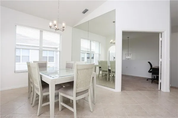 a dining room with furniture a chandelier and window