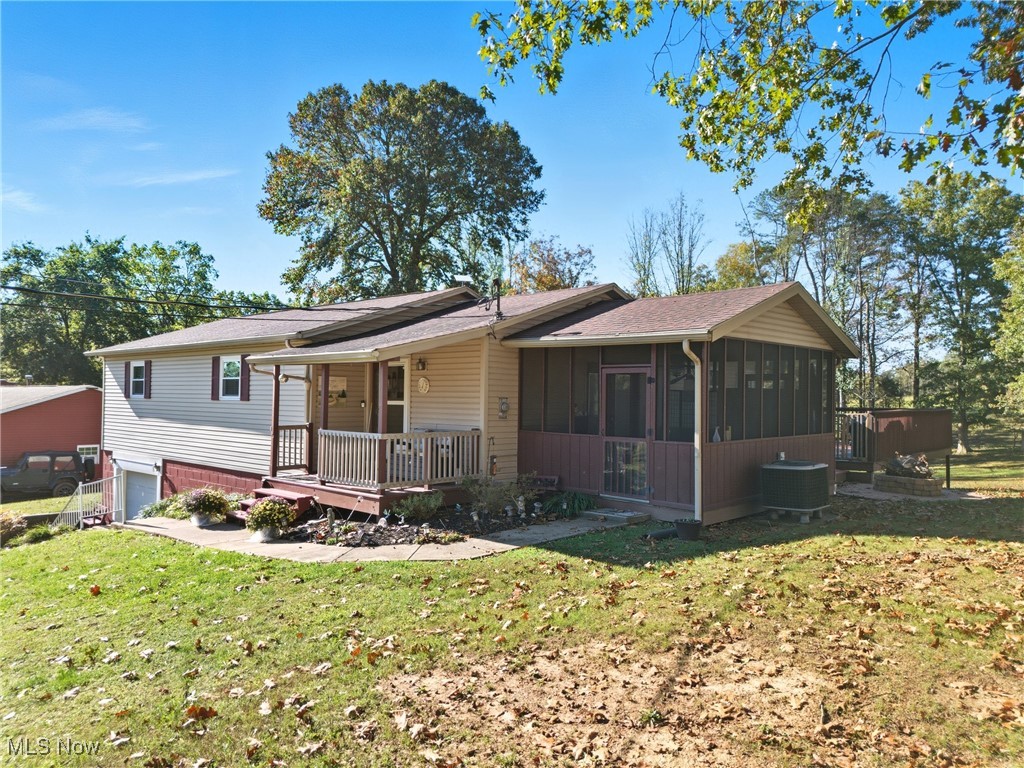 1788 Ashby Ridge Road Parkersburg, WV 26104 - Photo 6 of 46 View of front of home featuring a front yard, roof with shingles, a sunroom, and a wooden deck