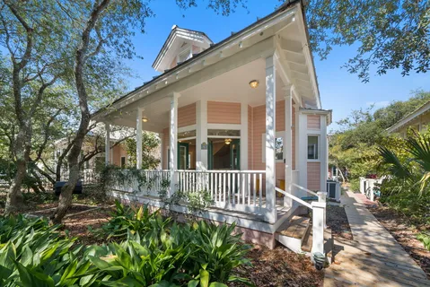 an aerial view of ocean and residential houses with outdoor space