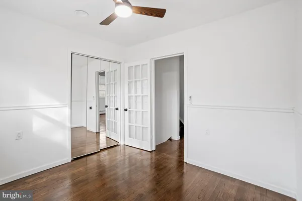 an empty room with wooden floor cabinet and windows