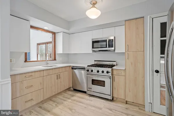 a kitchen with stainless steel appliances granite countertop a stove and a microwave