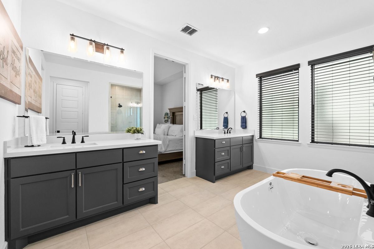 402 Fandango Boerne, TX 78006 - Photo 18 of 34 a bath room with a sink double vanity tub and a mirror