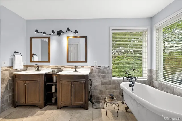 a bathroom with double vanity sinks a toilet a mirror and shower