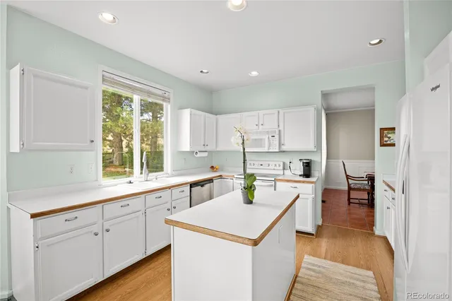 a kitchen with white cabinets and white appliances