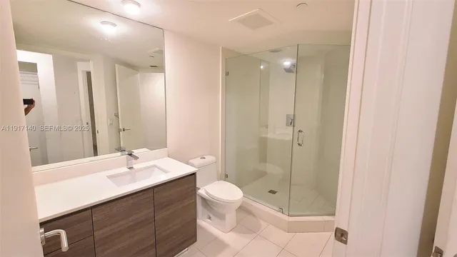 a bathroom with a sink vanity mirror and toilet