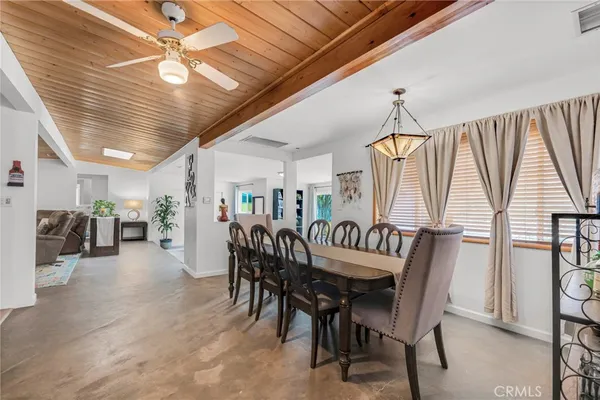 a large white kitchen with lots of wooden furniture a sink a stove and a dining table