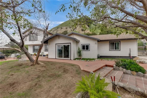 a view of a house with backyard and a tree