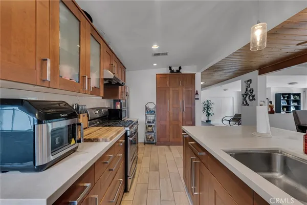 a kitchen with stainless steel appliances granite countertop a sink dishwasher stove top oven and refrigerator