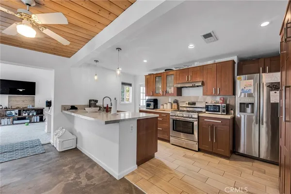 a kitchen with stainless steel appliances granite countertop a refrigerator and a sink