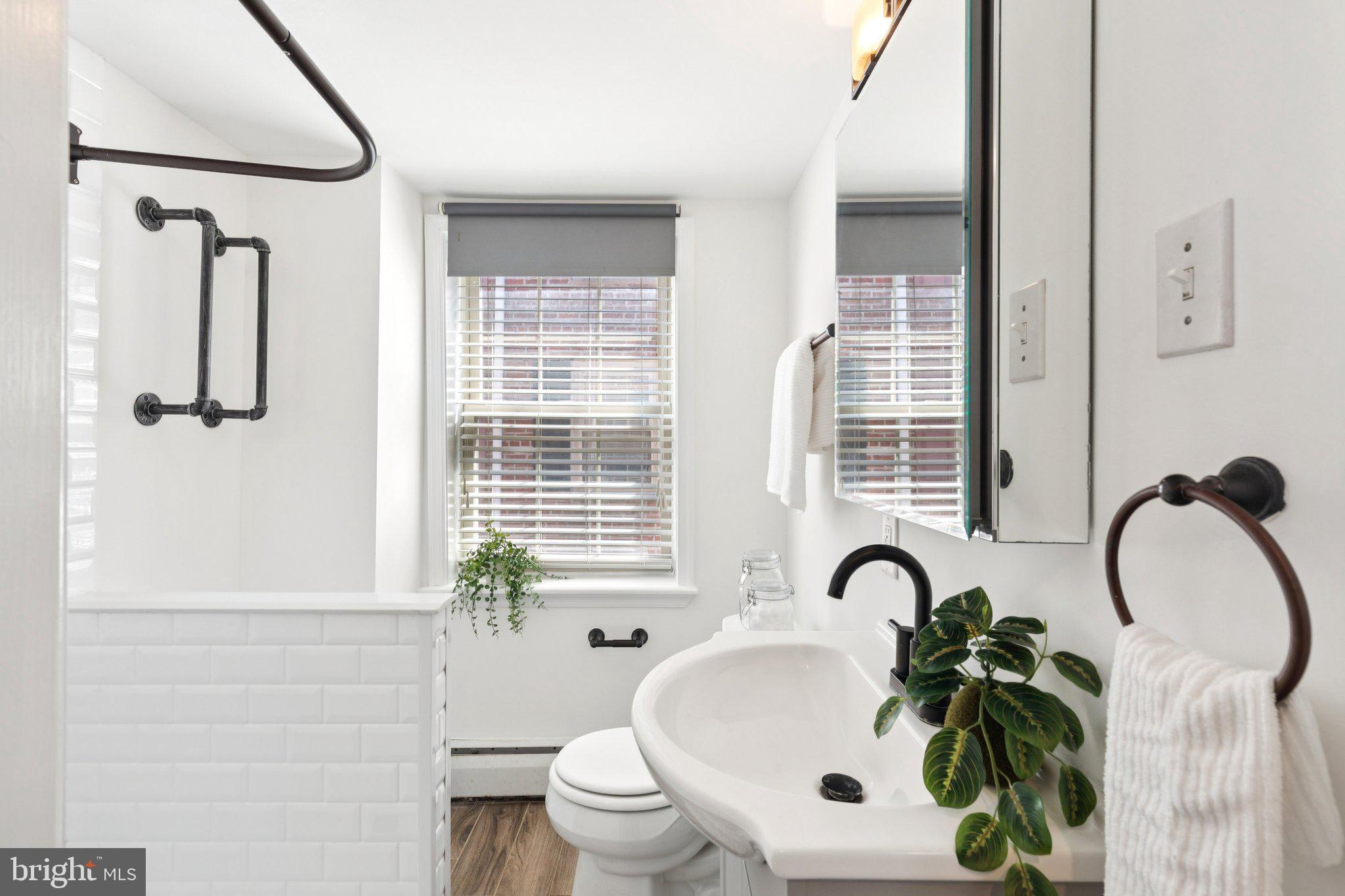 525 Fitzwater Street, Unit 4 Philadelphia, PA 19147 - Photo 13 of 20 a bathroom with a sink a toilet and a mirror