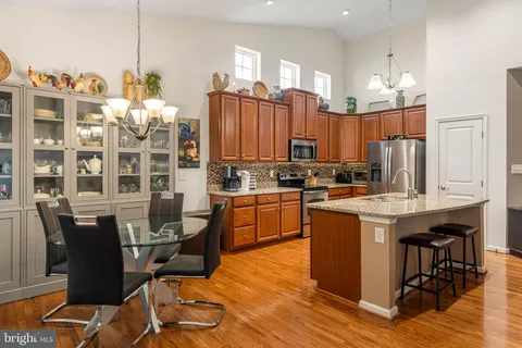 a kitchen with a table chairs appliances and cabinets