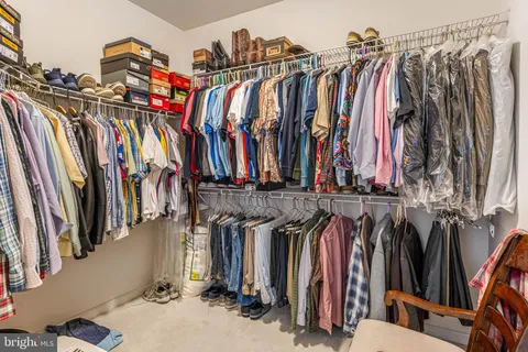 a view of walk in closet with clothes