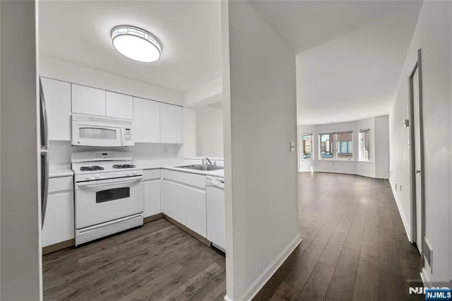 a kitchen with wooden floors and white appliances